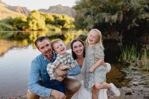 Dr. Wasson and family posing for a picture in front of a lake.