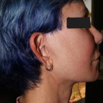 Profile photo: person with blue hair, black top, eyes obscured for privacy